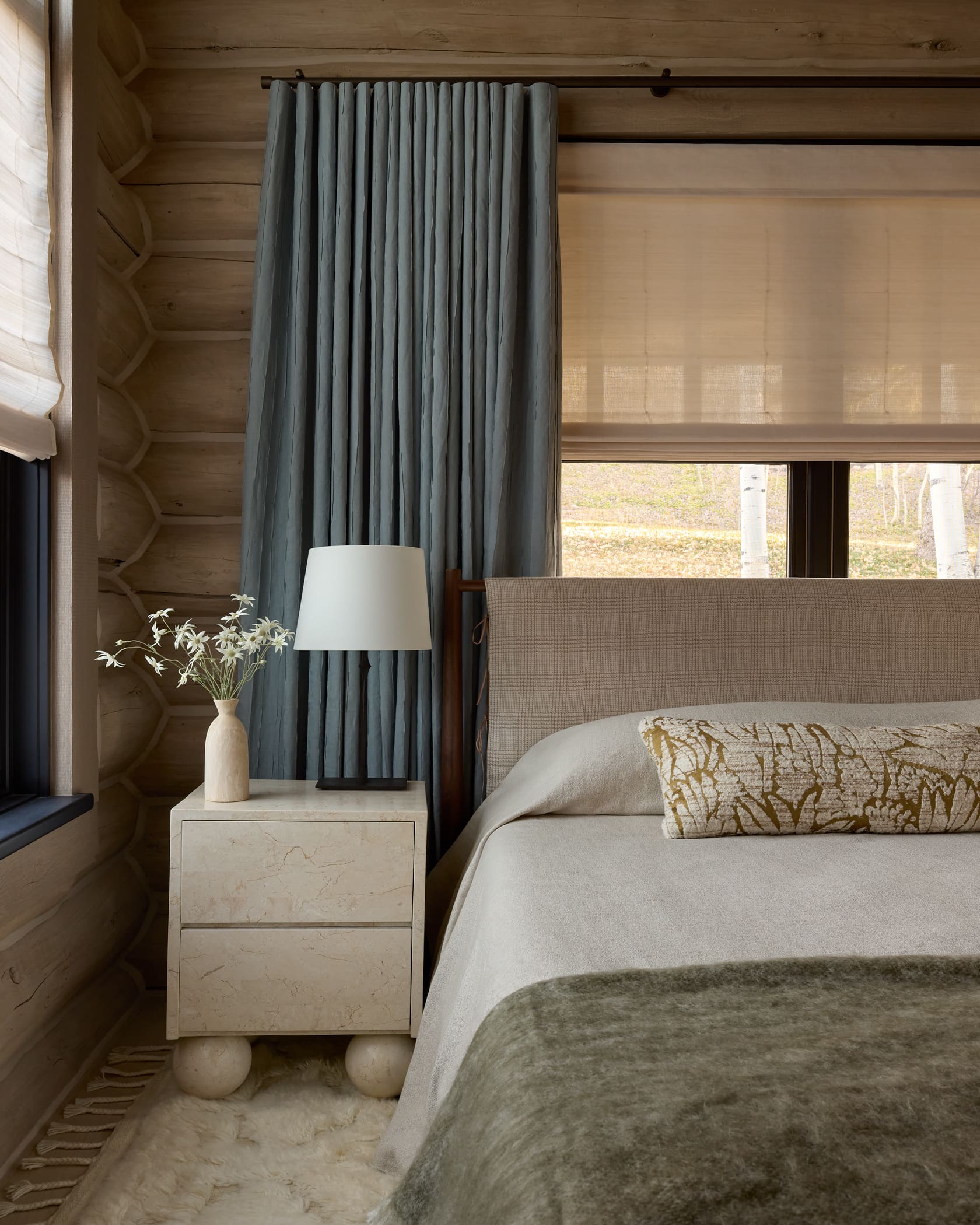 Guest bedroom with plaid headboard, stone nightstand, blue linen drapes, and Aspen grove views, Snowmass log cabin remodel